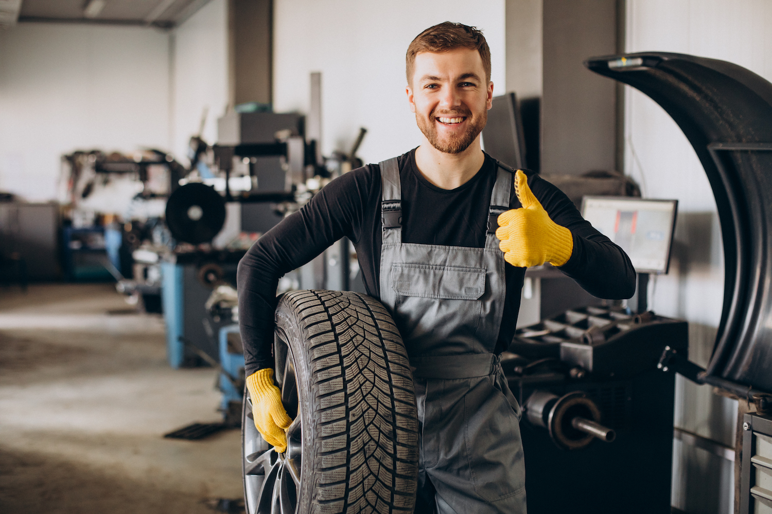 Man met autoband en duim opgestoken
